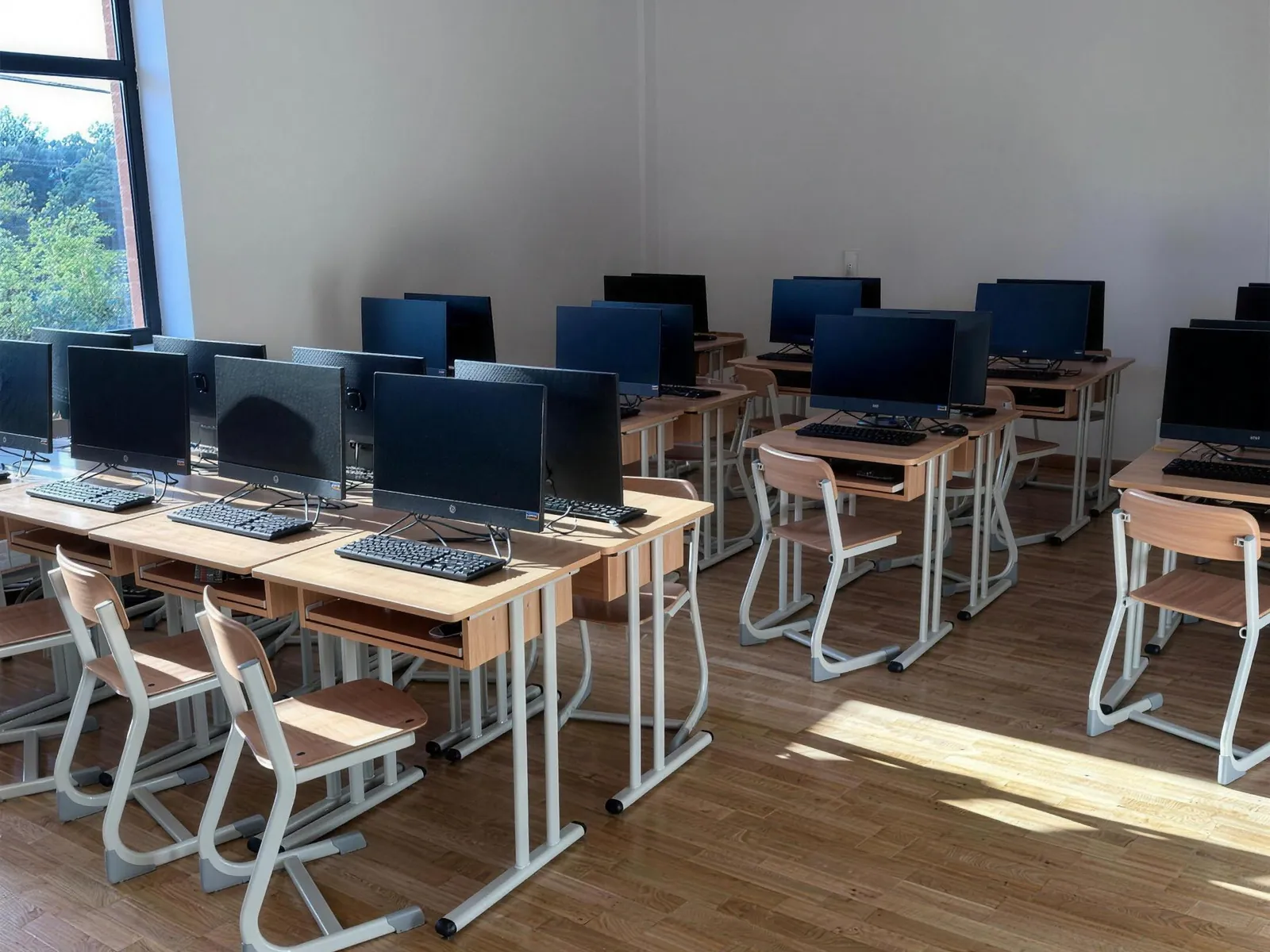Salle informatique avec rangées de postes informatiques et de chaises